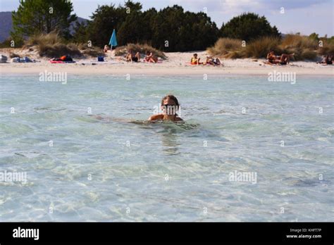 Eine hübsche junge Frau im Bikini schwimmen und Spaß im kristallklaren Wasser am Strand haben