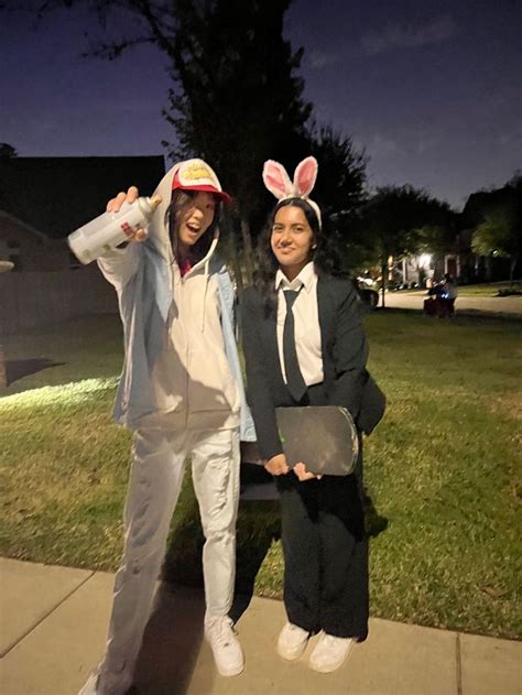 two people dressed up in bunny ears posing for the camera on a sidewalk ...