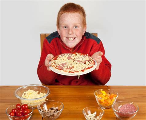 Muchacho Joven Que Muestra La Pizza Apagado Hecha Imagen De Archivo