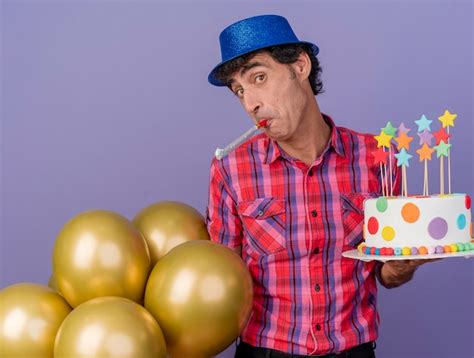 Impressionné homme de fête d âge moyen portant chapeau de fête tenant