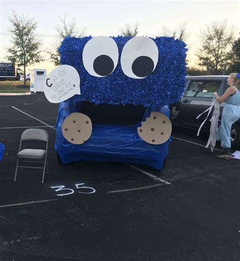 A Blue Couch Sitting In The Middle Of A Parking Lot Next To A Parked Car