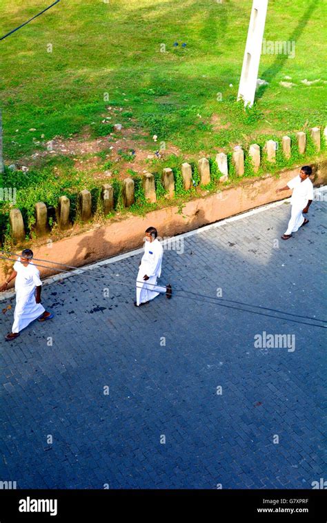 Three Men In White Robes Walking On A Street In Galle Sri Lanka Stock