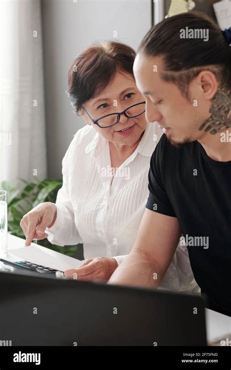 Mature Woman Asking Her Adult Son To Help With Paying Bills And Mortgage Loan Payment Stock