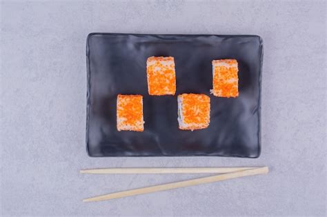 Free Photo Sushi Rolls With Salmon In Black Ceramic Platters