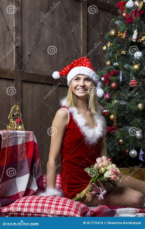 Beautiful Girl Dressed In Santa Suit Near Christmas Tree Stock Photo