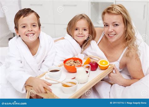 Mujer Que Desayuna En Cama Con Los Niños Foto de archivo Imagen de