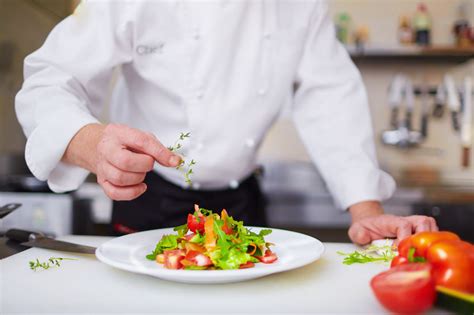 male chef garnishing fruit and veg dish at the kitchen - Durnins Fruit ...