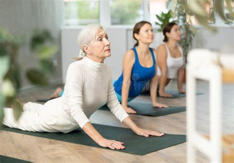 Mature Female Performing Bhujangasana Cobra Stretch Posture During