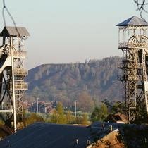 Two Large Metal Structures Sitting On Top Of A Hill Next To Trees And