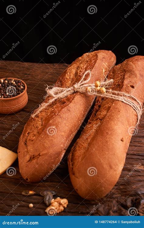 Two Fresh Baguettes On Dark Wooden Table Selective Focus Stock Photo