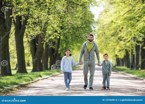 Padre Que Lleva A Cabo Las Manos Del Hijo E Hija Y El Caminar Foto De