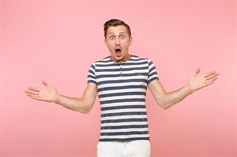 Portrait Of Surprised Shocked Man Wearing Striped Tshirt Spreading