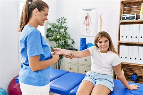 Woman And Girl Physiotherapist And Patient Having Rehab Session