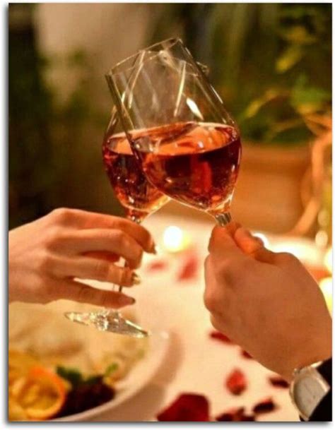 Two People Toasting Wine Glasses Over A Dinner Table