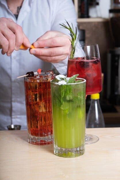 Premium Photo Alcoholic Cocktails With Ice In Glasses On The Bar Table