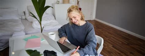 Portrait d une belle femme blonde souriante qui écrit des notes fait ses devoirs étudie à