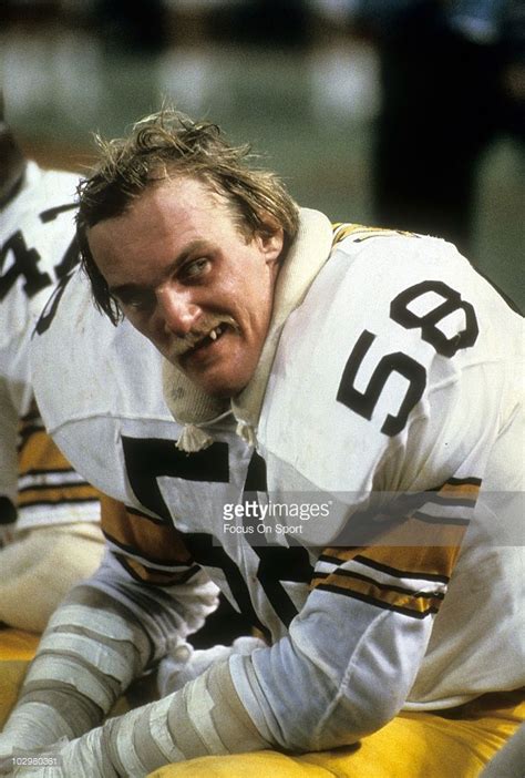 a football player sitting on the ground with his mouth open