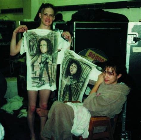 Two Women Holding Up T Shirts In A Room