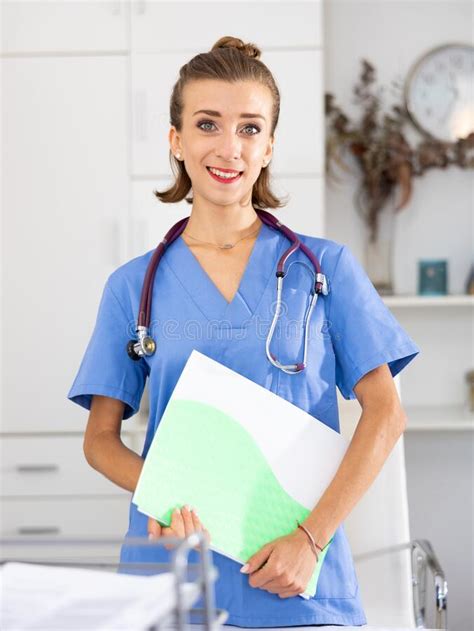 Portrait Of Female Doctor Wearing Uniform And Stethoscope With Folder