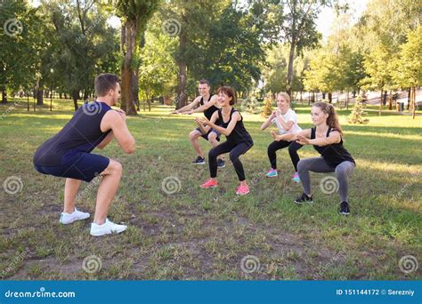 Group Of Young Sporty People Doing Exercise Outdoors Stock Photo