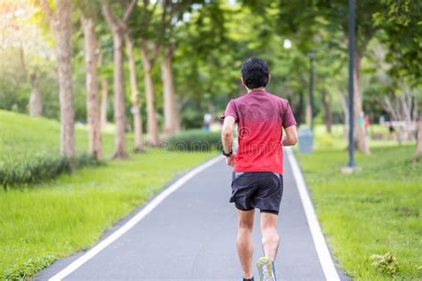 Young Adult Male In Sportswear Running In The Park Outdoor Runner Man