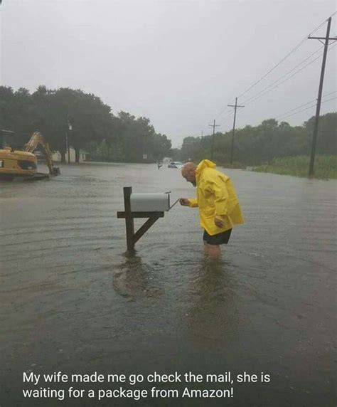 A Man In Yellow Jacket And Black Shorts Standing Next To Mailbox On