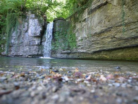 Waterfall Flowing Over The Rock Formation To The Ground Stock Photo