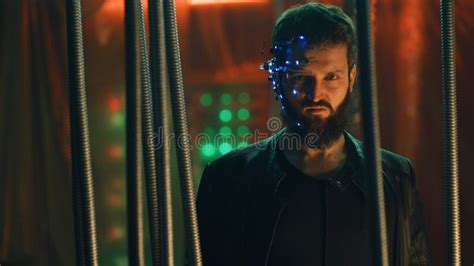 Brunette Guy In Cyberpunk Style With A Headset Stands Behind Black Hanging Rods Stock Image