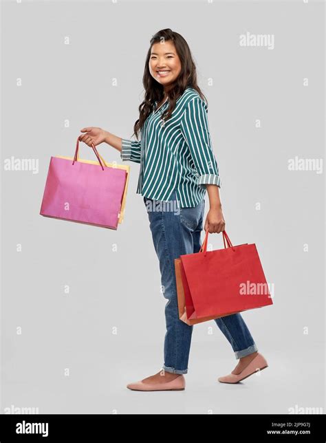 Happy Asian Woman Walking With Shopping Bags Stock Photo Alamy