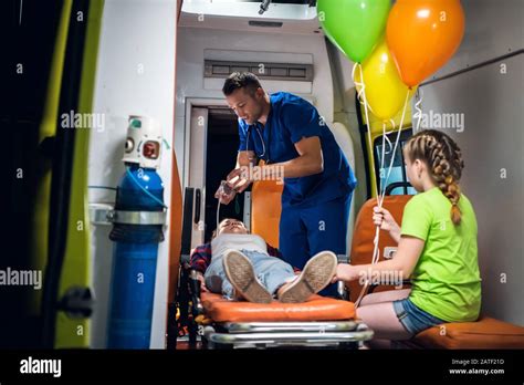 Ambulance Car Corpsman In Blue Medical Uniform Puts Oxygen Mask On