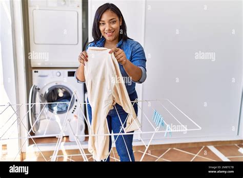 Hispanic Brunette Woman Hanging Clean Laundry On Rack At Laundry Room Stock Photo Alamy
