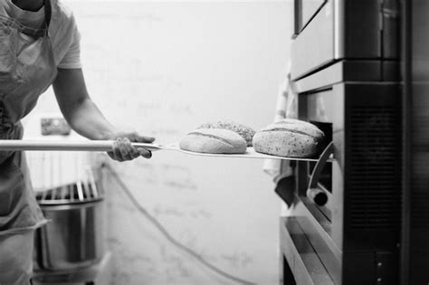 O Forno De Padeiro É Um Bem - Padeiro feminino usando uma casca para tirar um pedaço de pão do forno ...
