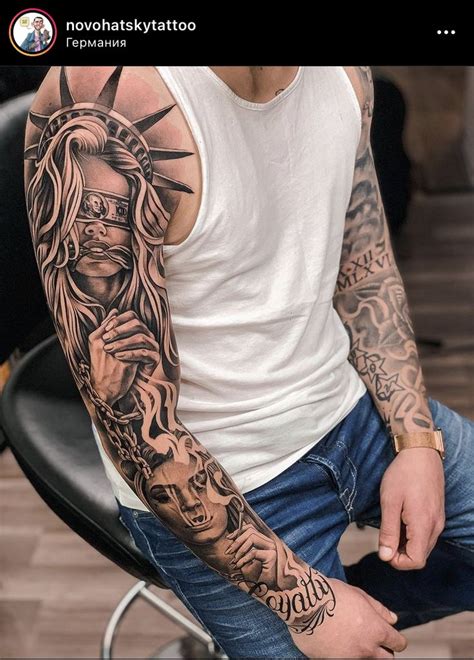 A Man With Tattoos On His Arm Sitting In A Chair