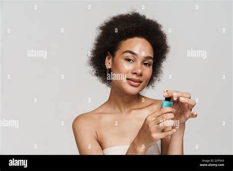 Black Curly Brunette Woman Smiling While Showing Nail Polish Isolated Over White Background