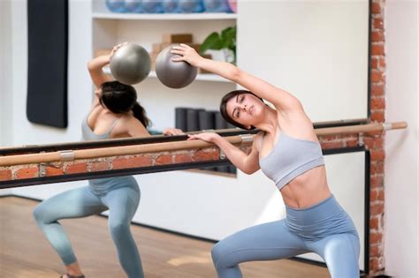 Premium Photo Female Ballerina Doing Plie Squat Near Barre