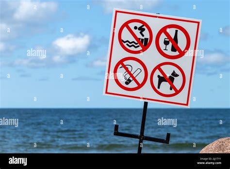 Beach Rules Signs Are On A White Banner Mounted On A Sea Coast Stock