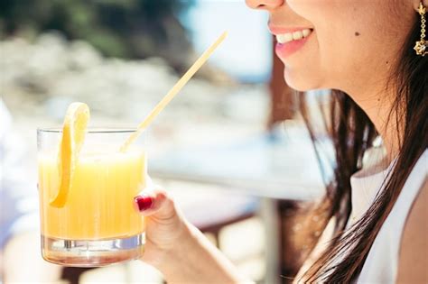 Premium Photo Midsection Of Smiling Young Woman Holding Cocktail