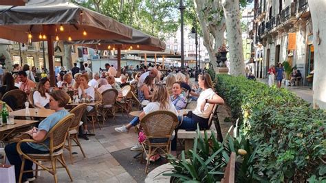 Els bars envaeixen de turistes els bancs d un dels carrers més