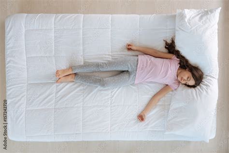 Cute little girl sleeping on the bed Stock Photo | Adobe Stock