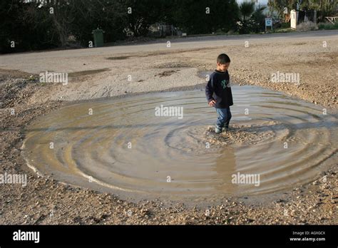 Boy Playing In Puddle Stock Photo Alamy