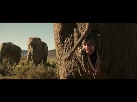 a woman is peeking out from behind an elephant's trunk in the middle of nowhere