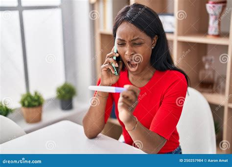 African Young Woman Holding Pregnancy Test Result Speaking On The Phone