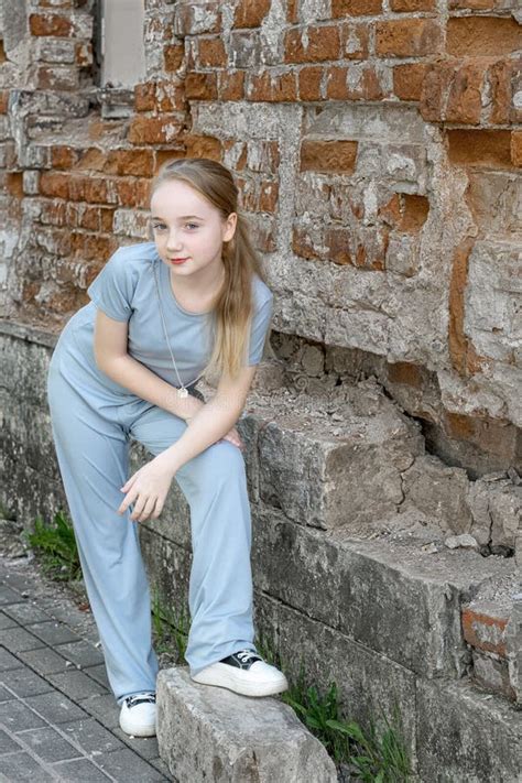 Portrait D une Belle Fille Blonde Avec Des Pigeons Devant Un Mur En Brique Jeune Fille Sérieuse