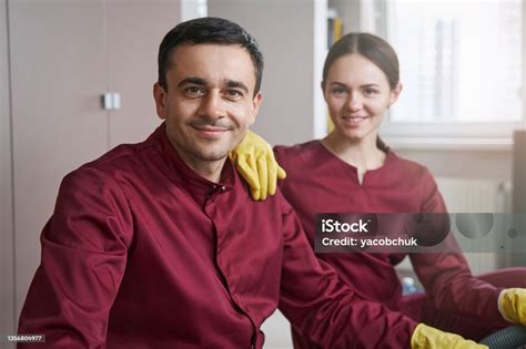 Smiling Janitorial Personnel In Uniforms Posing For Camera In Workplace ...