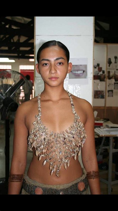 a young woman is standing in front of an art exhibit with jewelry on ...