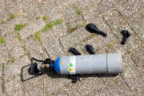 Cylinders with nitrous oxide and black balloons left in parking lot after use as drugs Stock ...