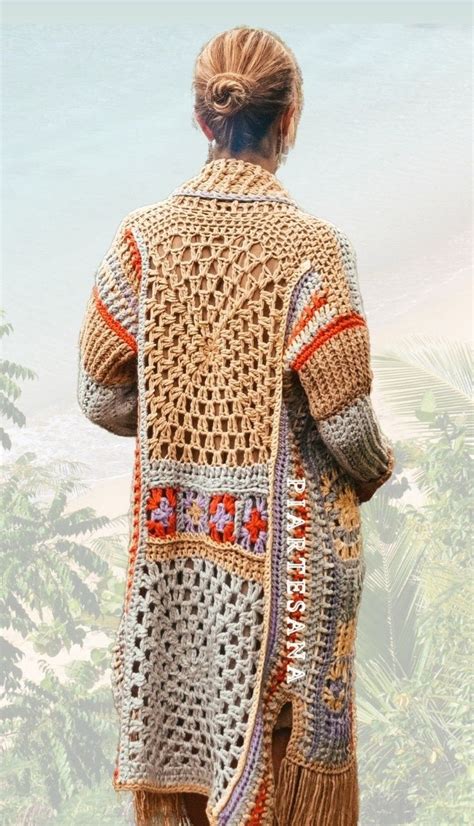 A Woman Standing In Front Of The Ocean Wearing A Crocheted Jacket