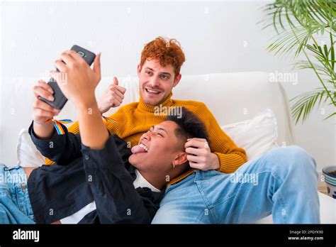 Beautiful Gay Couple Being Romantic Indoors On The Sofa Gay Couple