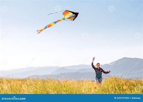 9yo Smiling Girl With Flying Colorful Kite Running On The High Grass