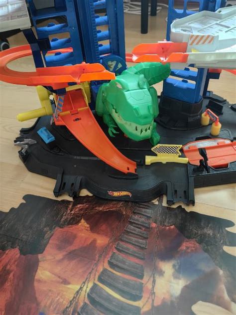 Hot Wheels City Toy Car Track Set Garaža z T Rex Dinozaurom
